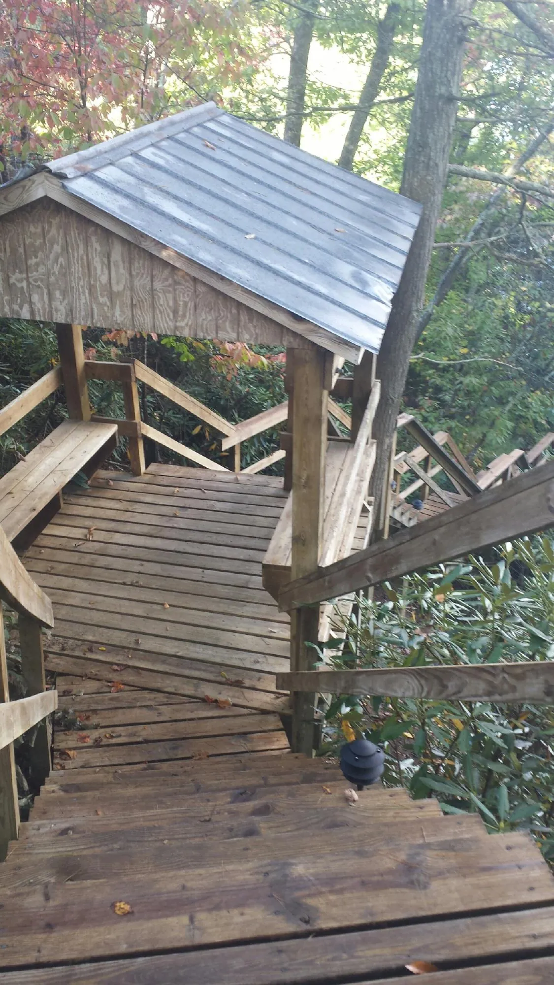 Metal roofed shelter over wooden steps on a wooded walkway — Skylight Repair & Installation work by our crew in Alloway