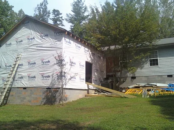 Tyvek wrapped gable on a new room addition beside an existing home in Alloway